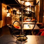 A decorative hookah on a restaurant table, representing the ambiance of a hookah lounge.