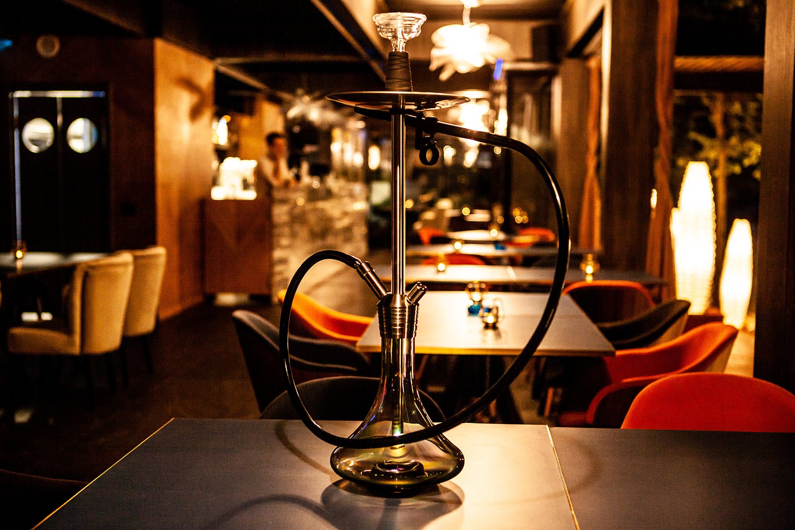 A decorative hookah on a restaurant table, representing the ambiance of a hookah lounge.
