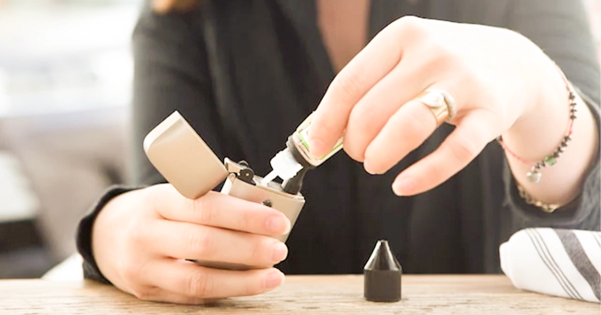 Person refilling a vaping device with liquid vape juice.
