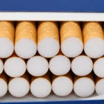 Open a blue-and-white cigarette pack filled with cigarettes.